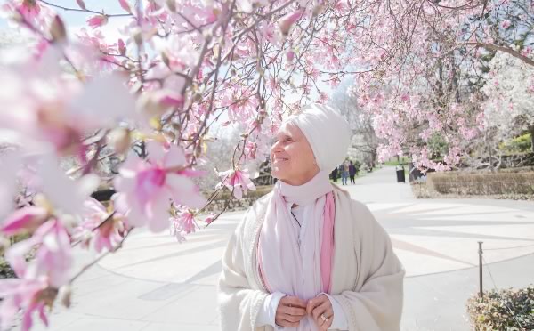 Woman in white byt cherry blossom trees